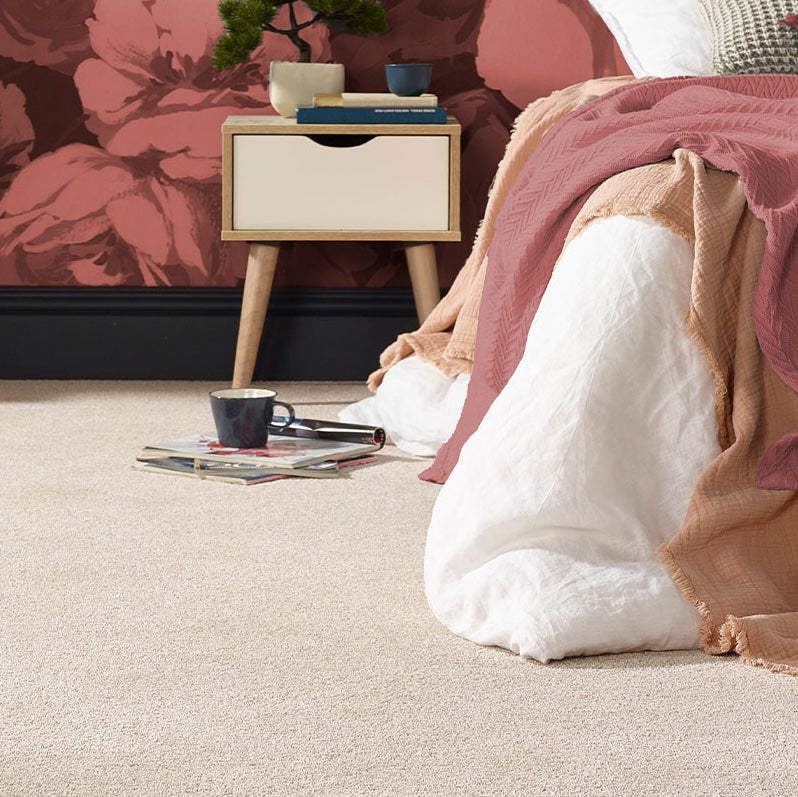 Cozy bedroom with a bed, nightstand, and floral wallpaper.