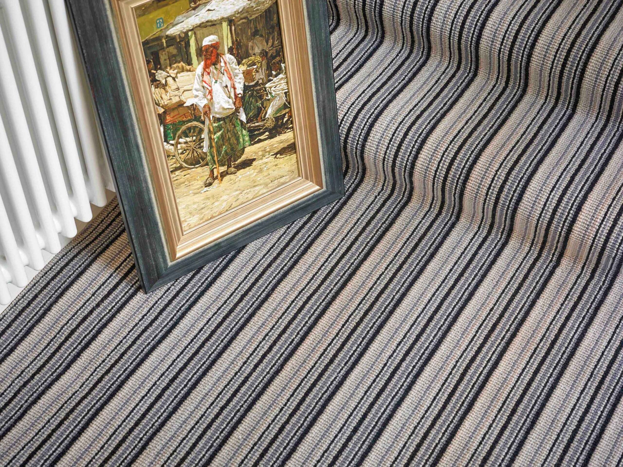 Framed artwork on a striped carpet