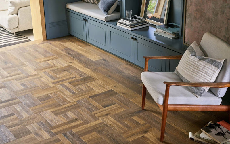 Wooden parquet flooring in a living room setting with furniture.