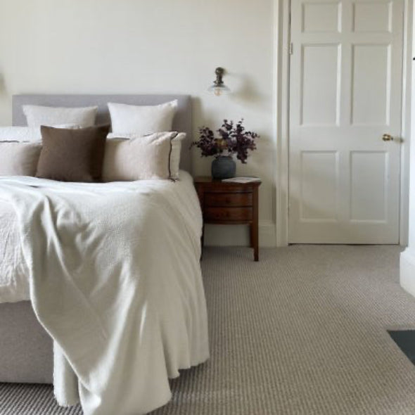 Neatly made bed with pillows in a bedroom setting.