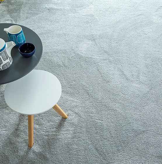 Gray carpet with a small round table and white stool